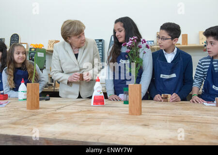 Berlino, Germania. Il 12 maggio 2015. Il cancelliere tedesco Angela Merkel parla con bambini durante una visita alla scuola di Roentgen in occasione di un progetto comunitario giornata a Berlino (Germania), 12 maggio 2015. Credito: dpa picture alliance/Alamy Live News Foto Stock