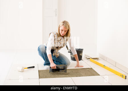 Home Improvement, ristrutturazione - handywoman piastrella di posa Foto Stock