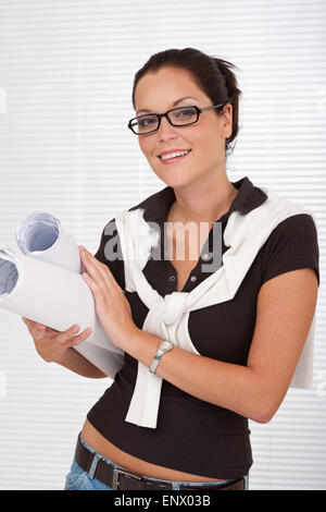 Donna sorridente architetto con vetri piani di contenimento Foto Stock