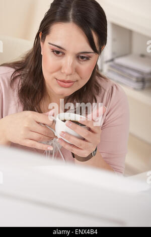 Giovane donna di affari godendo di caffè ad un ufficio moderno Foto Stock