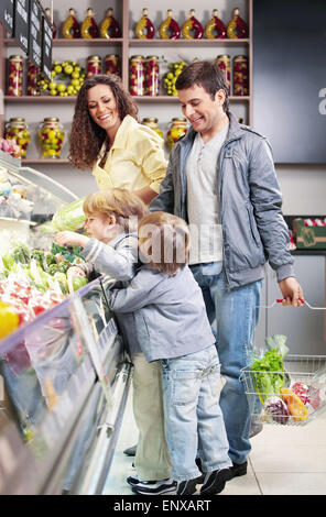 La famiglia con bambini sceglie prodotti in negozio Foto Stock