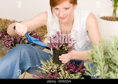 In estate terrazza giardino redhead donna vasi di fiore Foto Stock