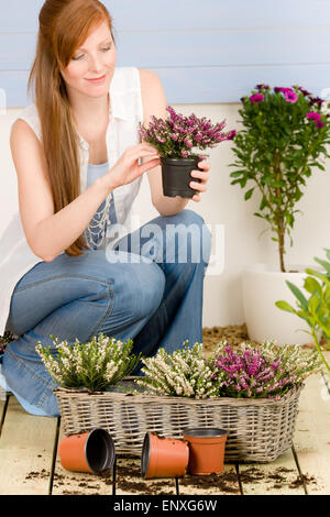 In estate terrazza giardino redhead donna fiore di attesa Foto Stock