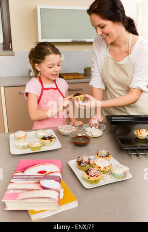 La figlia e la madre come decorare le tortine spruzza Foto Stock