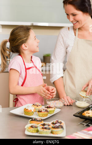 La figlia e la madre come decorare le tortine spruzza Foto Stock