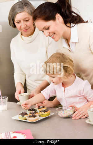 La figlia e la madre come decorare le tortine spruzza Foto Stock