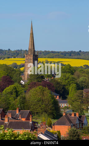 Chiesa di San Giovanni Evangelista domina il panorama nella piccola cittadina di Bromsgrove in Worcestershire con campi di semi di ravizzone o colza di dietro