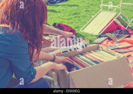 Ragazza di sfogliare di seconda mano gli album in vinile in scatole Foto Stock