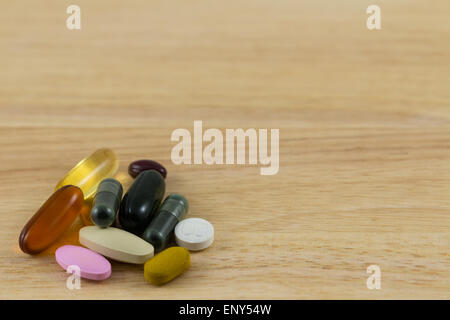 Pills versarsi sul blocco di legno Foto Stock