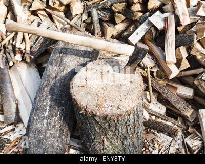 Legno ax del trinciapaglia nel blocco per la trinciatura di legna da ardere, catasta di legno sul cortile rustico Foto Stock