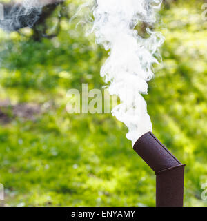 Fumo bianco dal camino di un samovar sul cortile Foto Stock