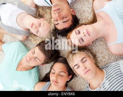 Elevato angolo di adolescenti con le loro teste insieme dormire a terra Foto Stock