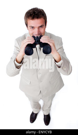 Imprenditore sorridente usando un paio di binocoli contro uno sfondo bianco Foto Stock