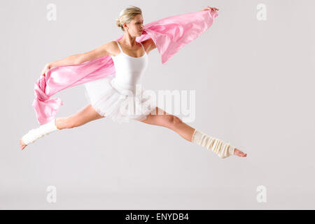 Graziosa ballerina jumping esercitando in studio Foto Stock