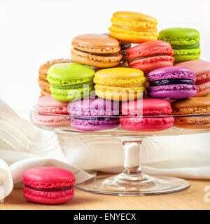 Francese macaron colorati in una torta di vetro stand Foto Stock