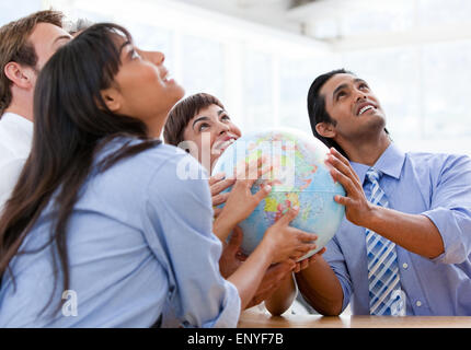 International Business team tenendo un globo terrestre Foto Stock