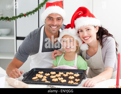 Donna felice con mio marito e mia figlia ith loro biscotti pronto Foto Stock