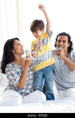 Adorable little boy cantando con i suoi genitori Foto Stock