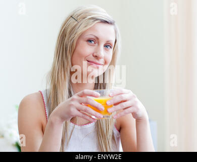 Ritratto di una donna attraente di bere un succo di arancio Foto Stock