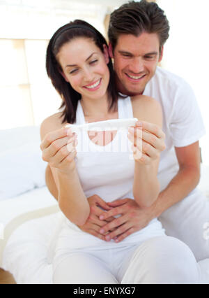 Sorridente giovane trovare i risultati di un test di gravidanza Foto Stock