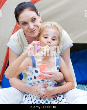 Bella madre con lui la figlia e il soffiaggio di aria Foto Stock