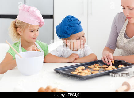 I fratelli e la loro madre assaggio dei loro biscotti Foto Stock