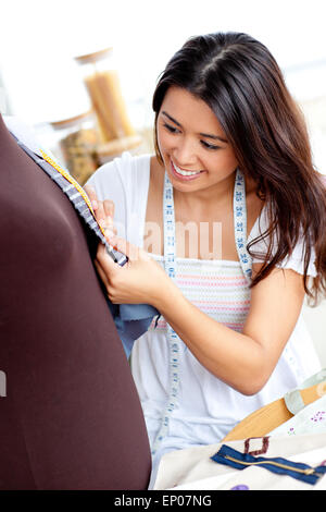 Bella donna asiatica cucire vestiti in cucina Foto Stock