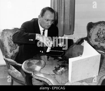 Deutscher Hörfunk- und Fernsehreporter Hermann Rockmann übet verbissen un einem Spielzeugklavier, Ende 1950er Jahre. Germania r Foto Stock