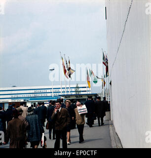 Besucher sehen sich die einzelnen Stände und Pavillons auf der Hannover Messe 1964 un. Visitatori e clienti a piedi sopra il H Foto Stock