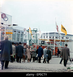 Besucher sehen sich die einzelnen Stände und Pavillons auf der Hannover Messe 1964 un. Visitatori e clienti a piedi sopra il H Foto Stock