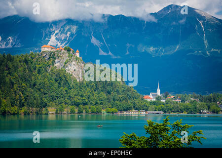 Il lago di Bled e Alta Carniola, Slovenia. Il castello di Bled si vede attraverso il lago. La città di Bled in background. Foto Stock