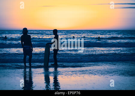 I giovani in piedi sulla riva Cavancha sulla spiaggia al tramonto in Iquique, Cile Foto Stock