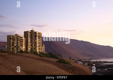 Moderno appartamento edifici lungo la costa meridionale della città poco dopo il tramonto in Iquique, Cile Foto Stock