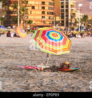 Parasole colorata in piedi la sabbia sulla spiaggia Cavancha in Iquique, Cile Foto Stock