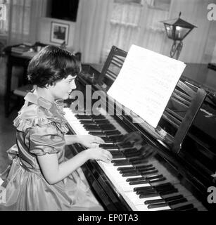 Ein Mädchen spielt un einem Flügel, Amburgo 1956. Una bambina gioca un pianoforte a coda. Foto Stock