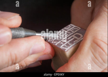 Uomo con le mani in mano porta utensile, carving cinese timbro di tenuta in Gaithersburg, Maryland. Foto Stock