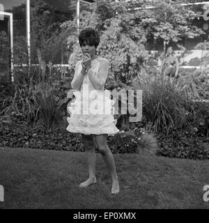 Deutsche Schauspielerin Uschi Glas als Sängerin barfuß im Garten vor der TV Sendung 'Musik aus Studio B', Deutschland 1960er Foto Stock