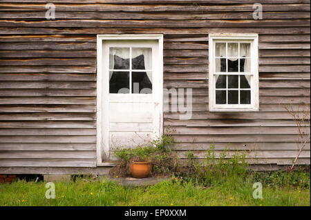 Close-up di casa con vecchi rivestimenti in legno e dipinti di bianco e porta finestra in Chrisfield, Maryland Foto Stock