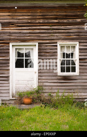 Close-up di casa con vecchi rivestimenti in legno e dipinti di bianco e porta finestra in Chrisfield, Maryland Foto Stock