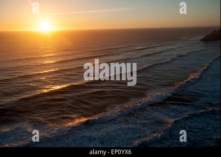 Golden onde che lambiscono la costa dell'Oregon, Stati Uniti d'America Foto Stock