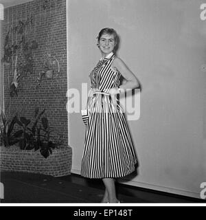 Eine junge Frau in einem gestreiften Kleid, Deutschland 1950er Jahre. Una giovane donna che indossa bello abito a strisce, Germania degli anni cinquanta. Foto Stock