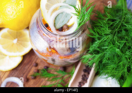 Le aringhe marinate in un vaso con le verdure e le erbe aromatiche Foto Stock