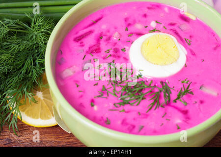 Fredda zuppa di barbabietole con erbe e uova sul tavolo Foto Stock