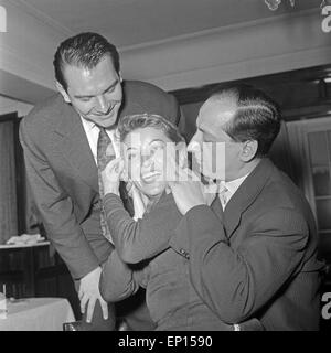 Zwei Männer albern mit einer jungen Frau in einem Ristorante, Deutschland 1950er Jahre. Due uomini scherzando con una giovane donna in un Foto Stock