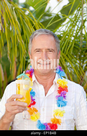 Uomo maturo di bere un cocktail sotto il sole Foto Stock