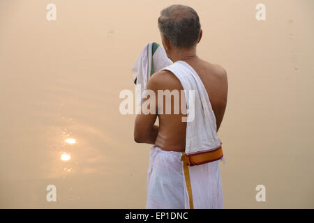 Uomo che prega al mattino sulla riva del fiume Gange. Foto Stock