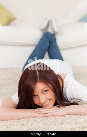 Stupendo i capelli rossi ponendo femmina mentre giaceva su un tappeto Foto Stock