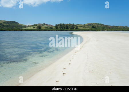 Vista posteriore di donna che cammina sulla spiaggia e impronte nella sabbia, Samar orientale, Filippine Foto Stock