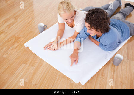 Uomo che mostra un punto su un piano per la sua ragazza Foto Stock