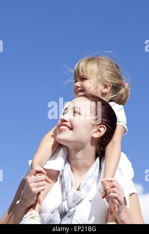 Madre dando sua figlia piggyback ride Foto Stock